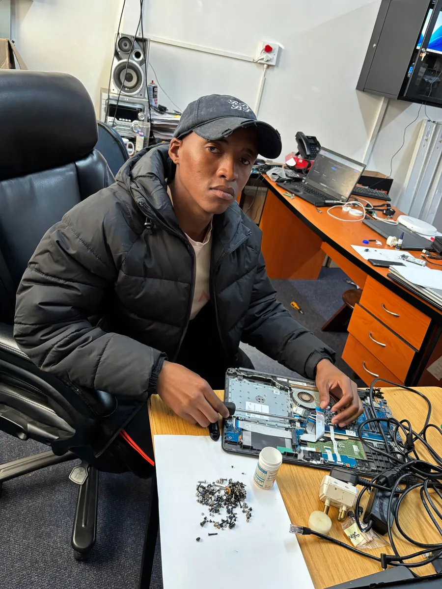 UXPERT technician at the workshop with a laptop being serviced
